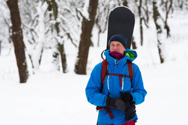istock Happy snowboarder stands in the winter forest 918480622