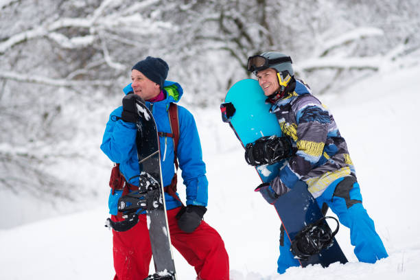 istock Two happy snowboarders relax after a successful descent 918480666