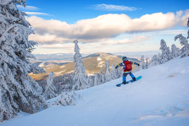 istock Snowboarder rides in mountains at sunny evening 918480678
