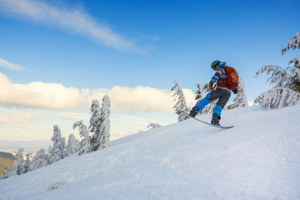 istock Snowboarder  jumps on the background of blue sky 918480686