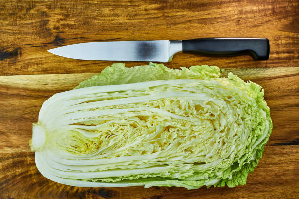 istock Chinese leaf lettuce, cut in half, and chef knife on a wooden board 918481806