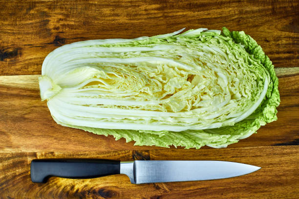 istock Chinese leaf lettuce, cut in half, and chef knife on a wooden board 918484702