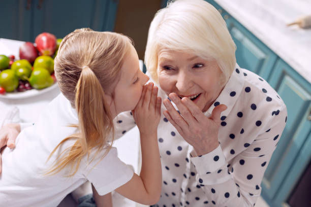 istock Cheerful girl and her grandmother sharing secrets 918489230