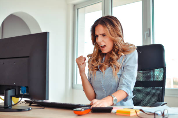 istock Working cute woman in front of a screen looking into camera in an office 918489760