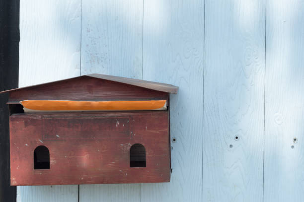 istock a pale -red mail box hanging on blue wodden background 918492462