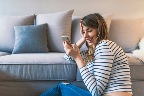 istock Young hipster girl using modern smartphone device while sitting at home and communicate with friend 918492790