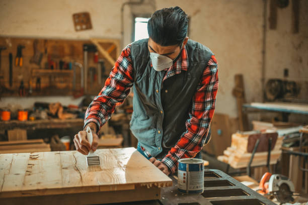 istock Carpenter applying wood stain 918492860