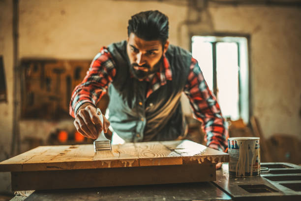istock Carpenter applying wood stain 918492862