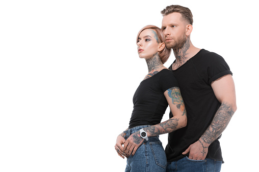 fashionable tattooed couple posing together, isolated on white