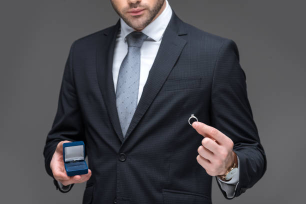 istock cropped view of elegant man proposing with ring, isolated on grey 918494510