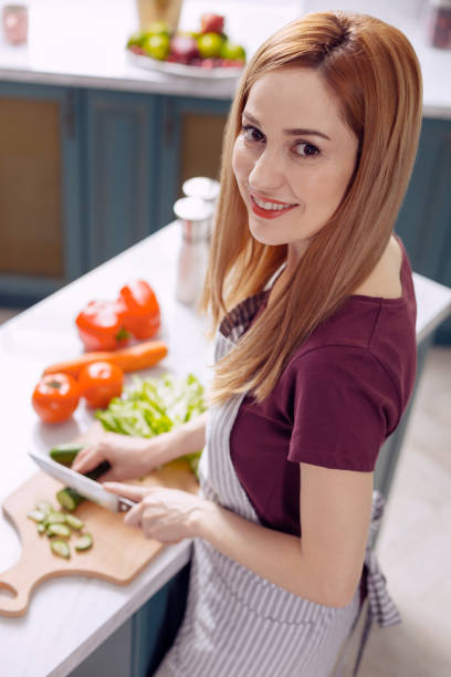 istock Young woman in apron making a salad 918494538