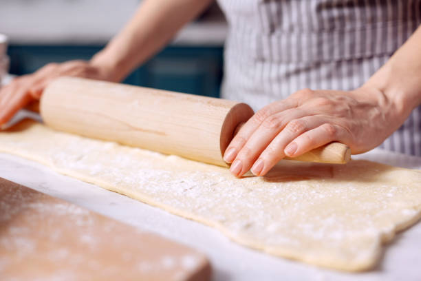 istock Close up of female hands rolling out dough 918497804