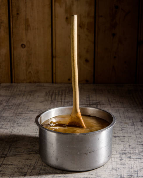 istock Thick Beef stock in pan with wooden spoon standing up on traditional kitchen worktop 918497836