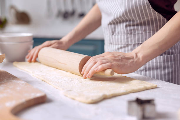 istock Young female rolling out dough on kitchen counter 918497852