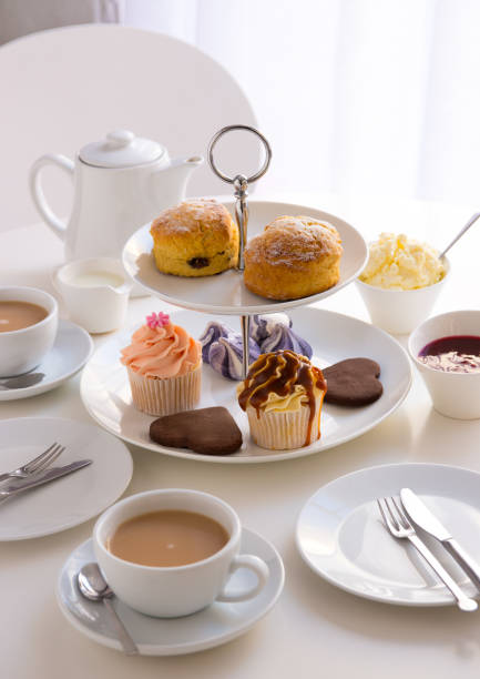 tabela de ajuste de lugar com chá com creme inglês e cupcakes - afternoon tea place setting cupcake cake - fotografias e filmes do acervo
