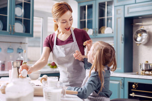 istock Happy mother being pleased by daughters help in cookie baking 918498430