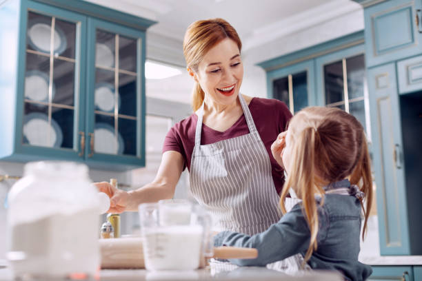 istock Cheerful woman wiping away flour from daughters forehead 918498550