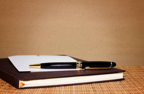 istock note paper and black pen on brown background 918505110