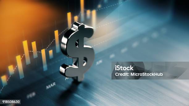 American Dollar Symbol Standing On Wood Surface In Front Of A Graph Stock Photo - Download Image Now