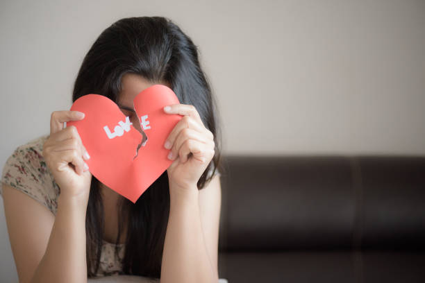 istock Woman holding red broken heart with love text. valentines day concept. 918508742