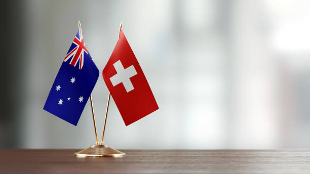istock Swiss And Australian Flag Pair On A Desk Over Defocused Background 918512768