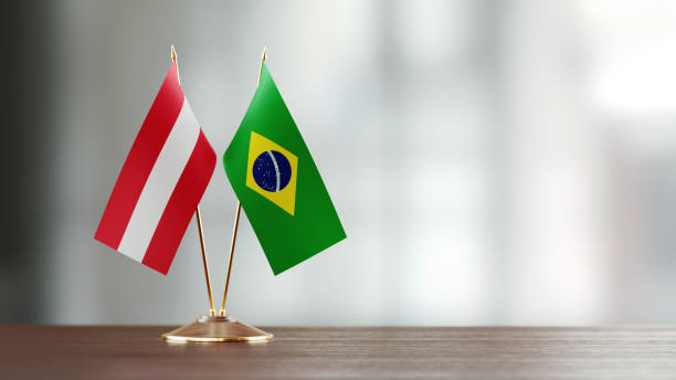 istock Brazilian And Austrian Flag Pair On A Desk Over Defocused Background 918515662
