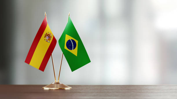 istock Brazilian And Spanish Flag Pair On A Desk Over Defocused Background 918515910