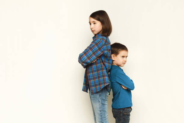istock Small girl and her brother standing back to back 918517928