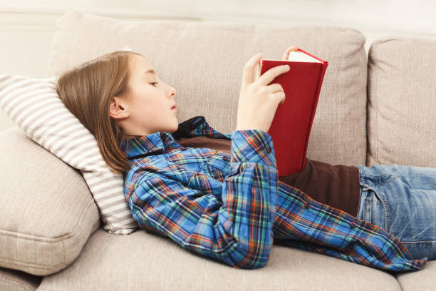 istock Cozy home. Young thoughtful girl with book 918518246