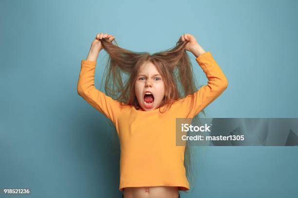 The Surprise Teen Girl On A Blue Background Facial Expressions And People Emotions Concept Stock Photo - Download Image Now