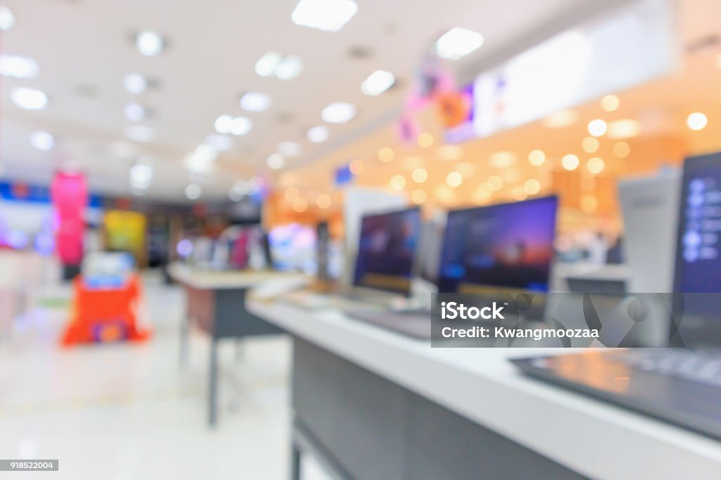 Computer notebook laptop on table at electronics store in shopping mall abstract blur defocused background Computer notebook laptop on table at electronics department store in shopping mall abstract blur defocused background Electronics Store Stock Photo