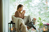 Young woman by the window with cup of hot coffee