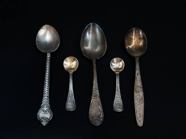 istock Old tea spoons of different sizes lie on a black background 918525018
