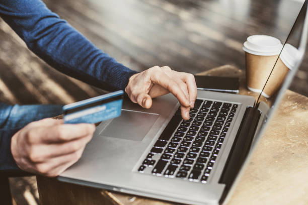 Man shopping online using laptop computer and credit card Internet shopper entering credit card information using laptop computer keyboard. Online shopping concept home shopping stock pictures, royalty-free photos & images