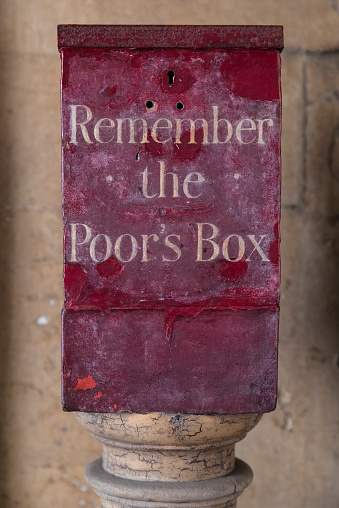 A Remember the Poors Box located at St. Bartholomews Hospital in London, UK.  Before the National Health Service, the sick were dependent on charity and public-giving was encouraged.