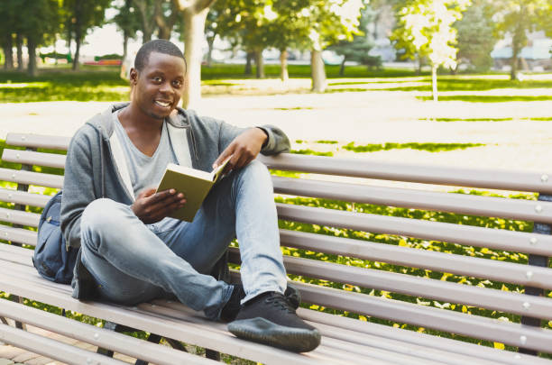 istock African-american student reading a book outdoors 918536134