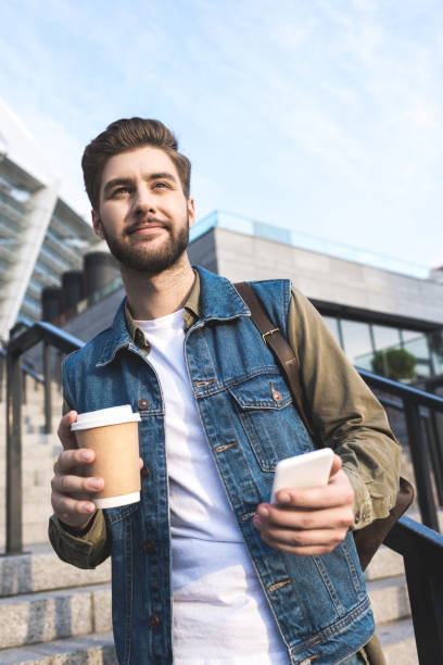 istock man with smartphone and coffee to go 918536246