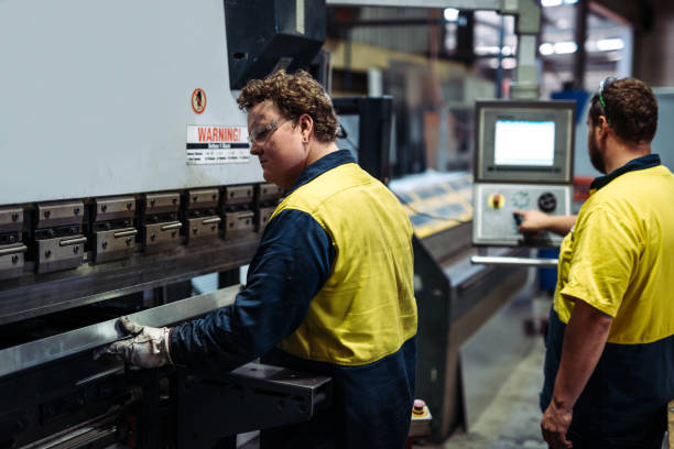 istock Workers in factory working on metal press machine 918536460