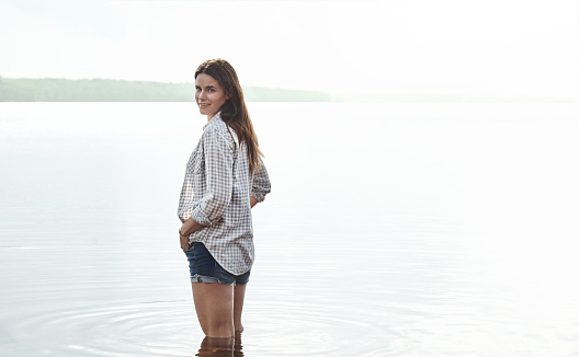Portrait of an attractive young woman standing in a lake