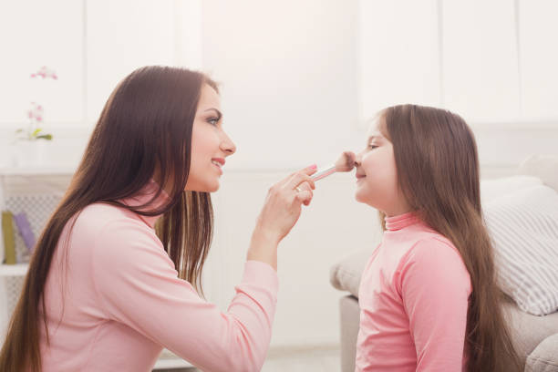 istock Mother and daughter doing makeup sitting on the floor 918549092