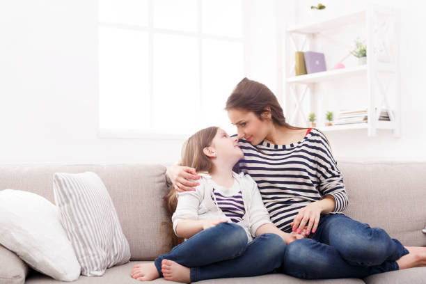 istock Mother with her cute little daughter sitting on the sofa. 918549462