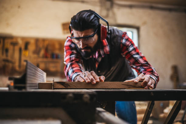 istock Carpenter cutting plank by circular saw 918549524