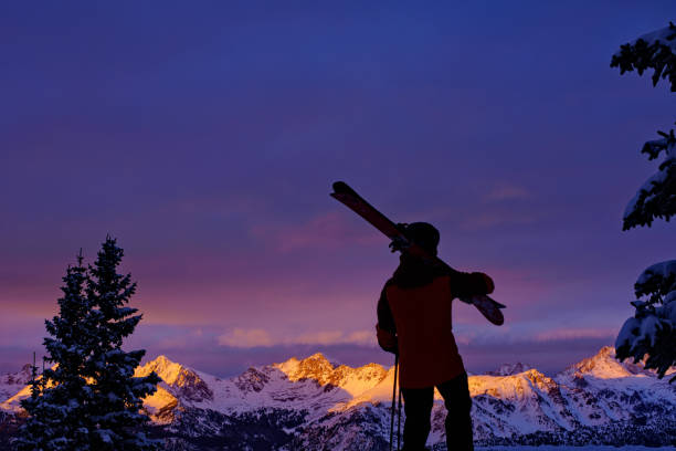 Man standing at top of ridge. Ski touring in mountains. Adventure winter freeride extreme sport.