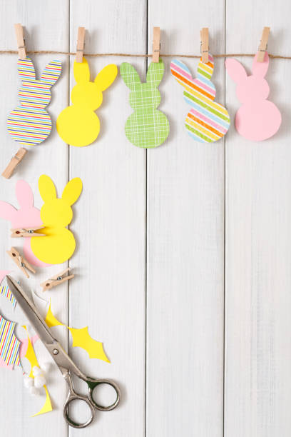 istock Garland with easter bunnies on white wood background, copy space 918551956