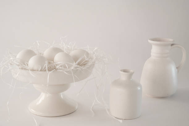 istock white romantic scene, cake stand with eggs, porcelain pottery, watering can, vase  against white background, space for text 918558280