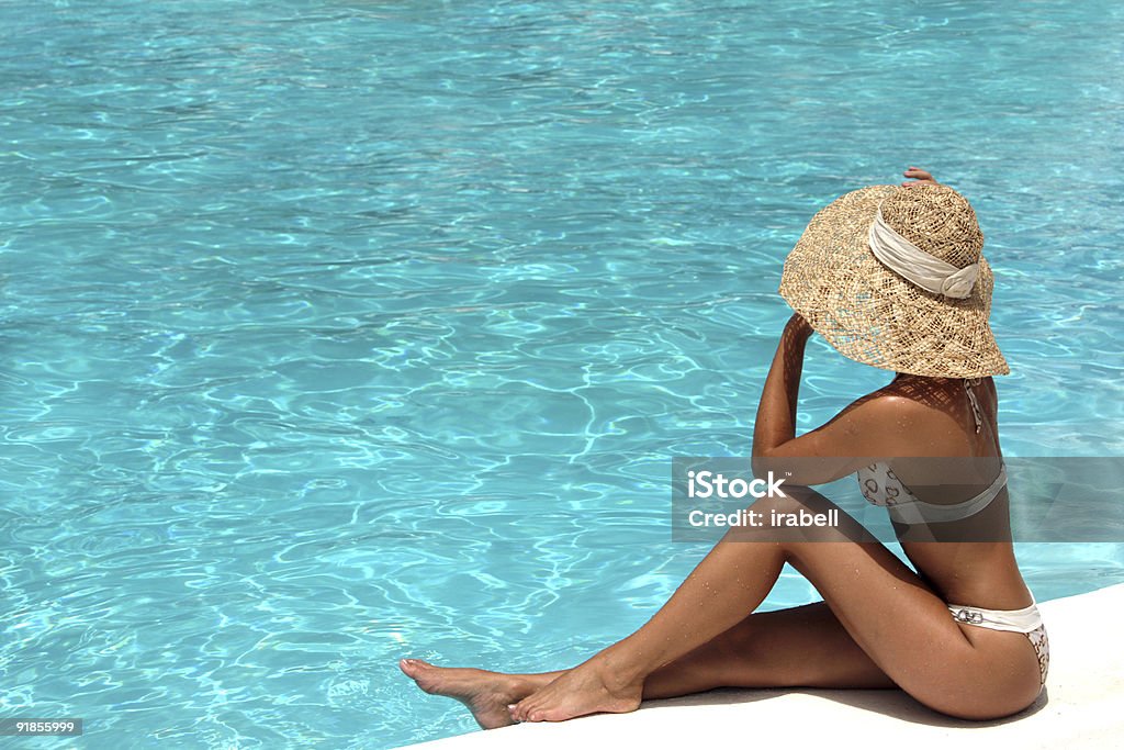 Donna in Cappello relax, accanto alla piscina - Foto stock royalty-free di Abbronzatura