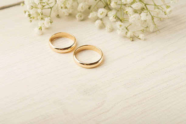istock Two golden wedding rings with flower decorations 918560906