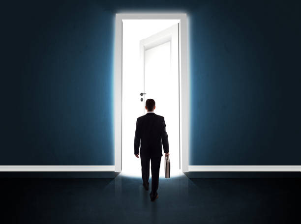 istock Business man looking at big bright opened door 918566112
