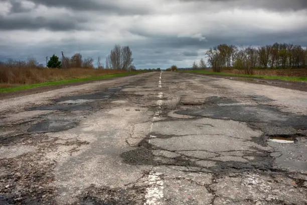 Photo of old road  potholes holes outside city autumn weather HDR