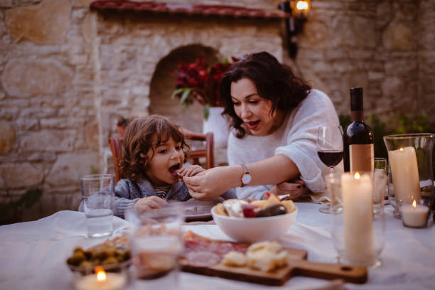 grossmutter und junge enkel am traditionellen cottage esstisch - spanisches essen stock-fotos und bilder